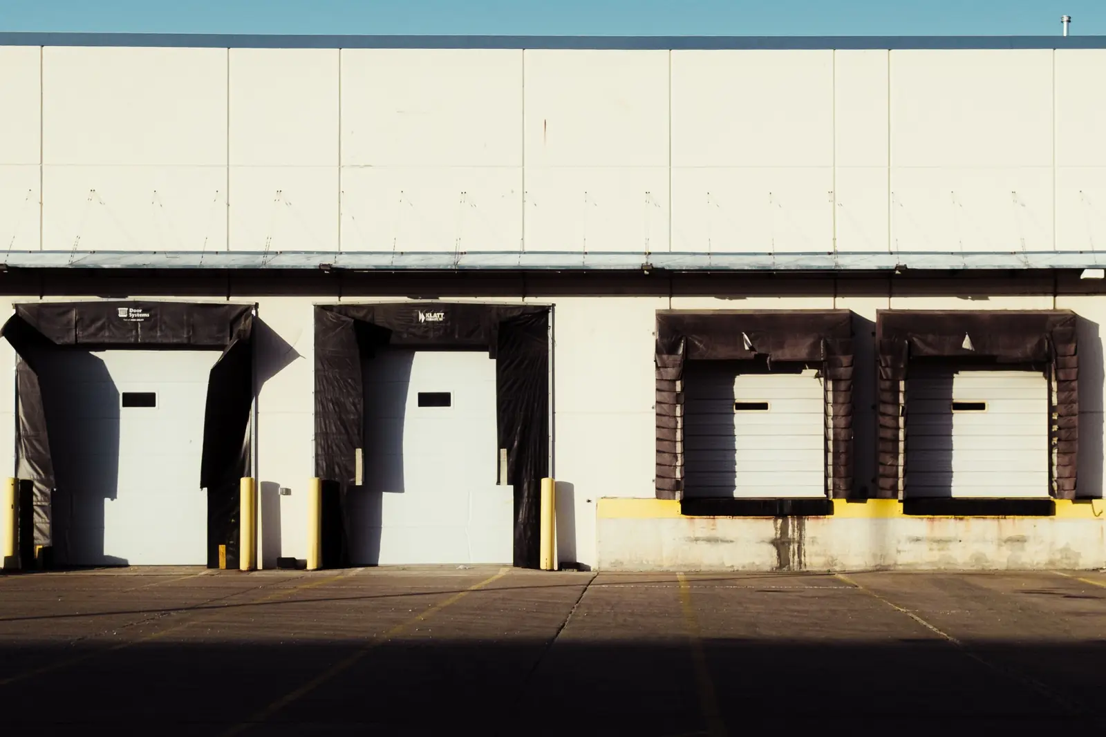 Quais de chargement d’un entrepôt logistique, portes ouvertes au soleil