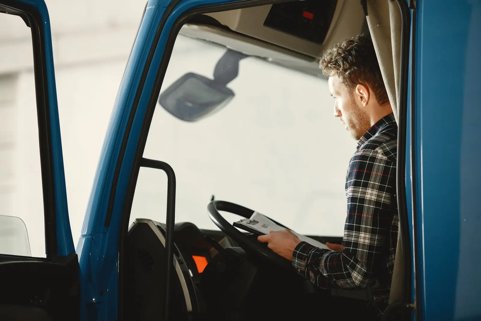 Conducteur professionnel vérifiant les documents de route dans la cabine du camion